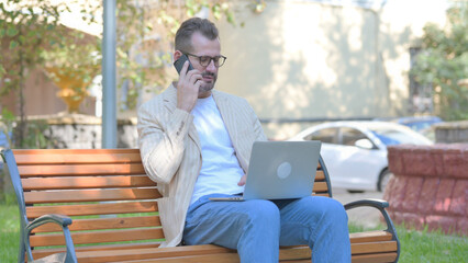 Fototapeta premium Modern Casual Man Working on Laptop and Smartphone