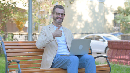 Thumbs Up by Modern Casual Man on Laptop Outdoor