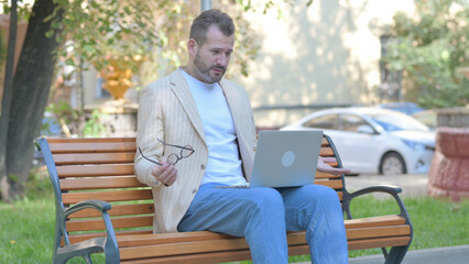 Obraz premium Modern Casual Man Shocked by Loss on Laptop Outdoor