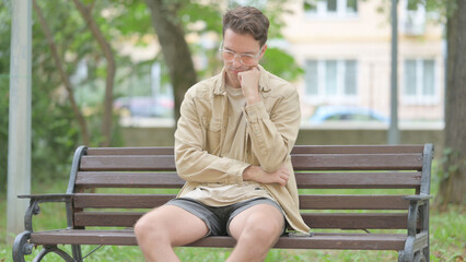Tired Casual Young Man Sleeping while Sitting on Bench