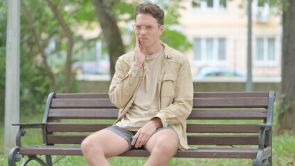 Casual Young Man with Toothache Sitting Outdoor
