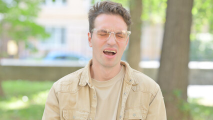 Outdoor Portrait of Upset Casual Young Man Reacting to Failure