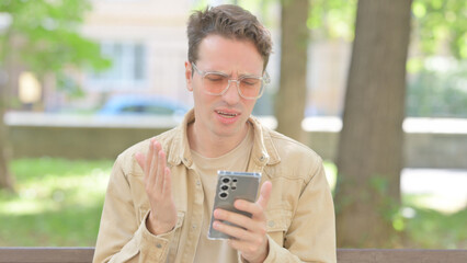 Upset Casual Young Man get Shocked on Smartphone Outdoor