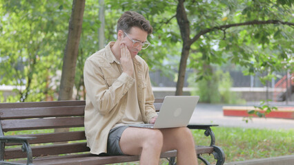 Modern Young Man with Toothache Using Laptop Outdoor