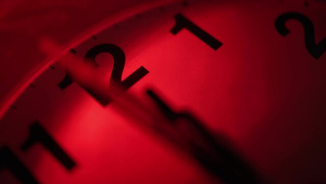 The clock shows the time 00:00. Midnight. Red light. Time passes, shadows move. Close-up.