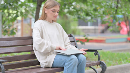 Fototapeta premium Young Woman Coming, Sitting on Bench and Working on Laptop