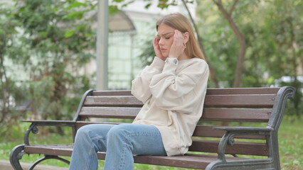 Casual Young Woman Sitting Outdoor with Headache