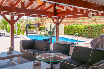 relaxation area in the villa with chairs and a table, near the pool, there is a place to relax 