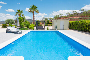 modern villa with swimming pool and sun loungers for relaxation. Beautiful summer landscape
