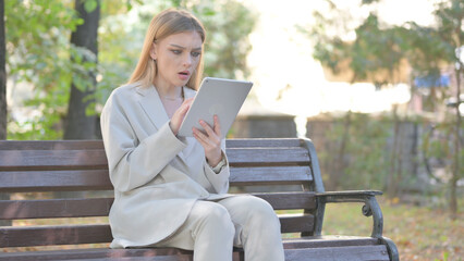 Obraz premium Young Business Lady with Loss on Tablet while Sitting on Bench on a Bench