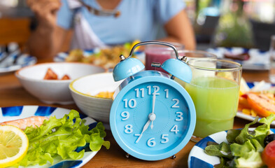 Blue alarm clock with IF (Intermittent Fasting) 16 and 8 diet rule and weight loss concept.-Diet...