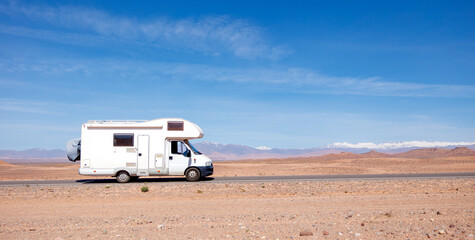 motorhome on the road in desert landscape- road trip, travel, freedom concept