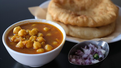 Chole Bhature is a food dish popular in the Northern areas of the Indian subcontinent. It is a combination of chana masala (spicy white chickpeas) and bhaturapuri, a deep-fried bread made from maida.