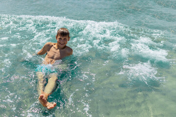 Happy boy swims and dives under water Active healthy lifestyle, water sports, seascape with a child 