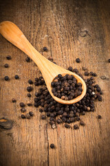 black pepper on wooden spoon