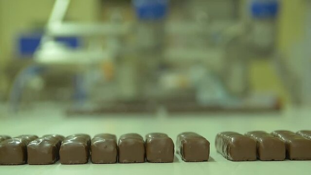 static slow motion medium shot of freshly made chocolate bars on a conveyor line