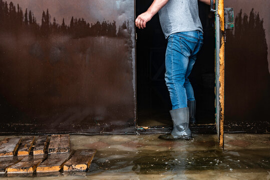 A man enters the garage flooded with water after the rain.