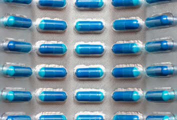 Blue medicine tablet in blister pack, close up.