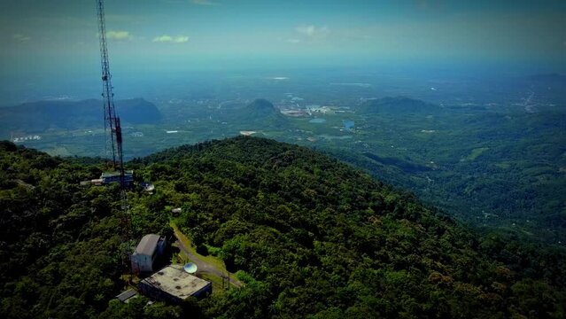 High angle photo of a forested high mountain peak in Thailand. with a tower that transmits telephone signals