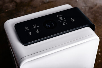 The dehumidifier with a touch panel works in the basement after filling with water. Air dryer.