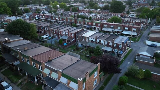 High crime neighborhood in urban American city at night. Dangerous area of row houses in USA. Aerial establishing shot at dark.