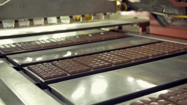 dolly slow motion medium shot of freshly made chocolate bars on the conveyor line