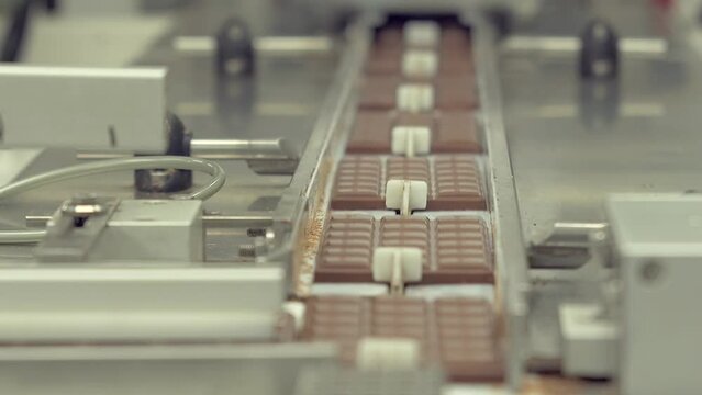 static slow motion medium shot of chocolate bars changing the direction of movement on the conveyor line