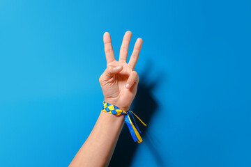 Three fingers up on a blue background. This is a symbol of the Ukrainian coat of arms and victory