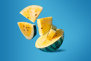 Flying slices of yellow watermelon on a blue background. Ukrainian flag concept - 646691943