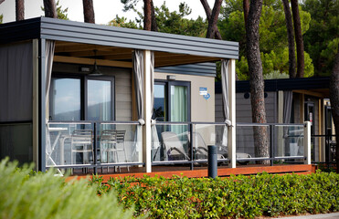 Luxury mobile homes with a terrace in a campsite on the island of Krk in Croatia, Europe. Modern camping houses for accommodation on the coast of the Adriatic sea in Croatia. - obrazy, fototapety, plakaty