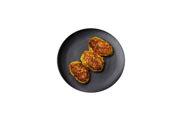 Diet vegetable cutlet from zucchini, carrot, herbs on a black plate