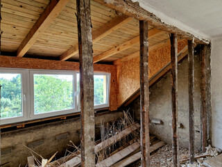 Fototapeta premium demolition of the attic of an old house. partitions made of boards and bricks were destroyed by a team with pneumatic hammers. it looks like it was hit by a missile or an earthquake.