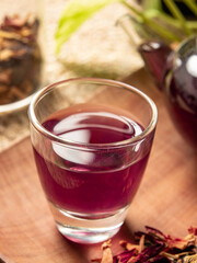 Fresh tea is served in a teapot on a placemat, isolated with a wooden patterned wicker background.