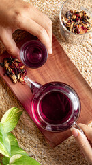 Fresh tea is served in a teapot on a placemat, isolated with a wooden patterned wicker background.