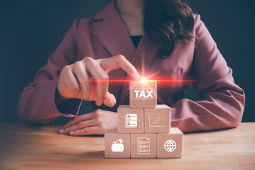 Businesswoman hand pointing wooden cube block with TAX icon. Tax deduction planning, income tax return, personal income tax, tax payment, vat, property tax, Business and finance concept.