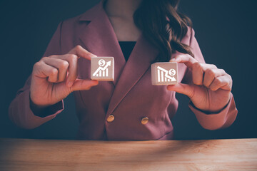 Businesswoman showing wooden cube blocks with dollar sign arrow up and down. increase profit and...