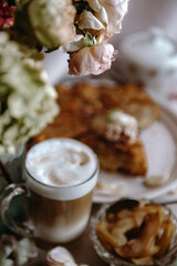 homemade apple pie with a cup of cappuccino and flowers