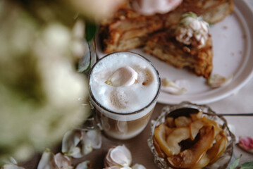 homemade apple pie with a cup of cappuccino and flowers