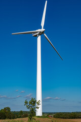 wind turbine standing in field with blue sky
