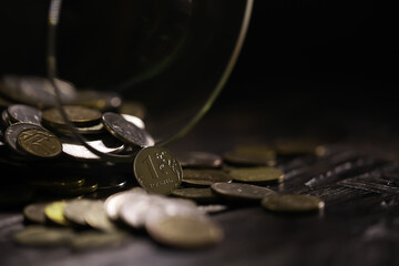 Russian rubles and metal coins inside a glass jar close-up on black blurred background