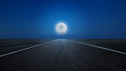 Asphalt road with a meadow field view with a full moon © Leo Lintang