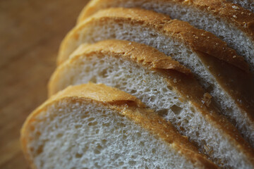 long loaf on a wooden board and knife isolated on a white background. Tasty bread