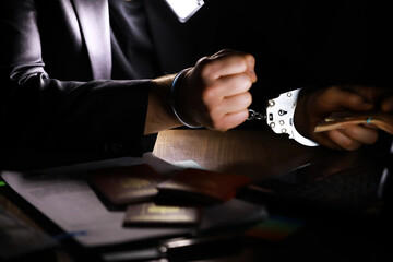 Hands in handcuffs behind, holding five thousand rubles. Concept of corruption
