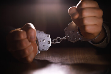 stressed out businessman hands bothered with handcuffs suffering at custody for concept of...