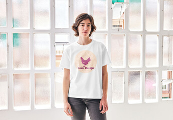 Mockup of woman wearing customizable color t-shirt by window, front view
