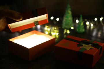 Gift boxes against a background bokeh of twinkling party lights. Luxury New Year gift. Christmas gift. Christmas background with gift box. Christmastime celebration