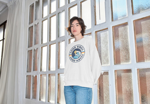 Mockup of woman wearing sweatshirt with customizable color by window with camera flash