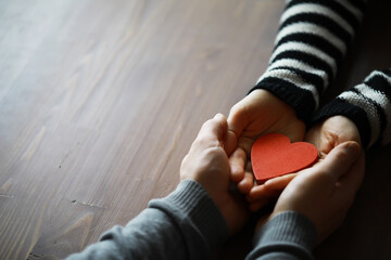 Hands of a woman holding and offering a heart shape. Love, health concept. Selective focus.Cinematic effect.