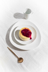 Cheesecake with Raspberry Jam and Coffee on a Minimalist Table, White Background with Text Space