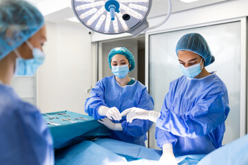 Surgical team performing surgery in modern operation theater,Team of doctors concentrating on a...
